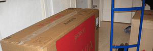 Tippet Richardson moving a Sony Bravia 40-inch LCD in a brown box with a small blue trolley