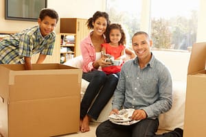 Mixed race family of four moving into their new place unpacking all of their belongings from the long-distance move