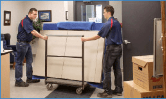 Two Tippet Richardson movers moving office equipment using a trolley