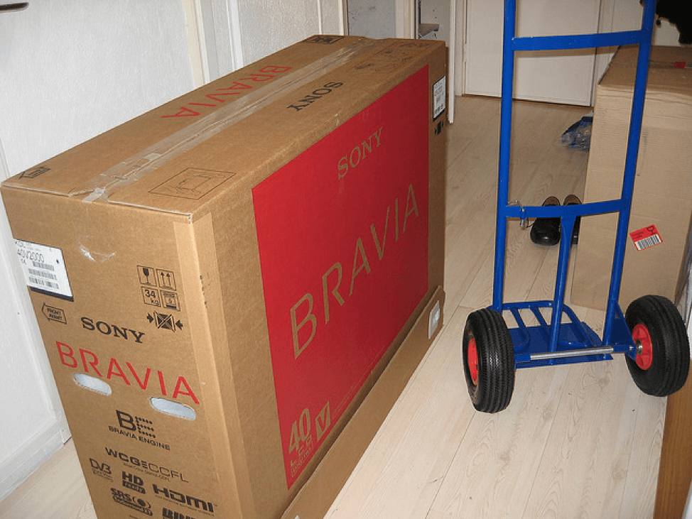 Tippet Richardson moving a Sony Bravia 40-inch LCD in a brown box with a small blue trolley