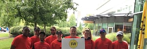 All T-R staff wearing red t-shirts in front of a building holding up a white T-R sign for the Corporate Kids Challenge 2017